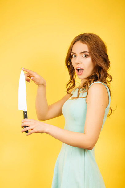 girl with kitchen knife checks the sharpness - Φωτογραφία, εικόνα