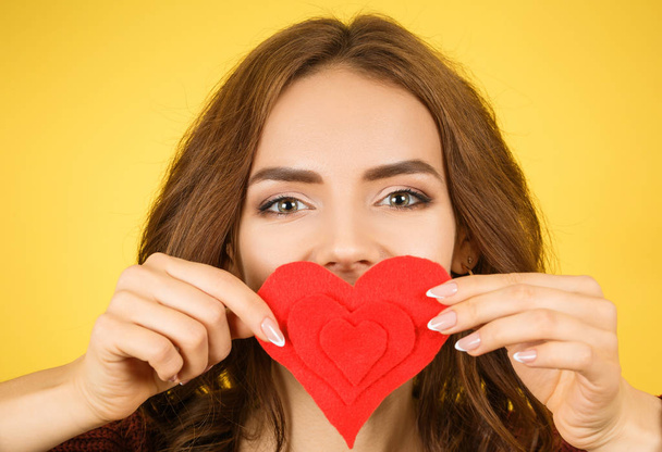 mulher cobrindo sua boca com coração vermelho
 - Foto, Imagem