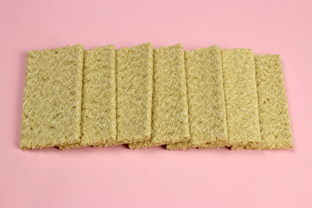 Verspreid kruimelbrood van maïs op een roze achtergrond. Dieet, goede voeding, Veganistisch - Foto, afbeelding
