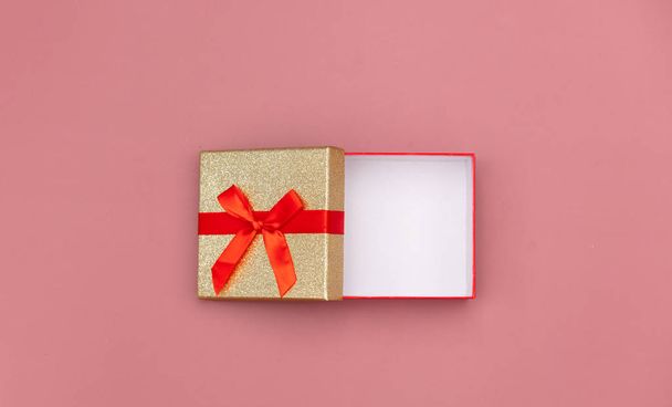 Маленькая подарочная коробка на розовом фоне. Вид сверху
  - Фото, изображение
