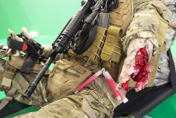 Schaufensterpuppe eines verwundeten Kämpfers mit einer schweren Wunde auf einer Trage. Medizin - Foto, Bild