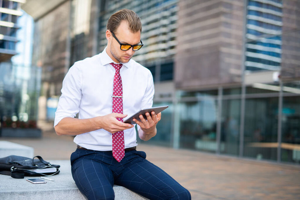 Businessman using a digital tablet in an urban environment - Photo, Image