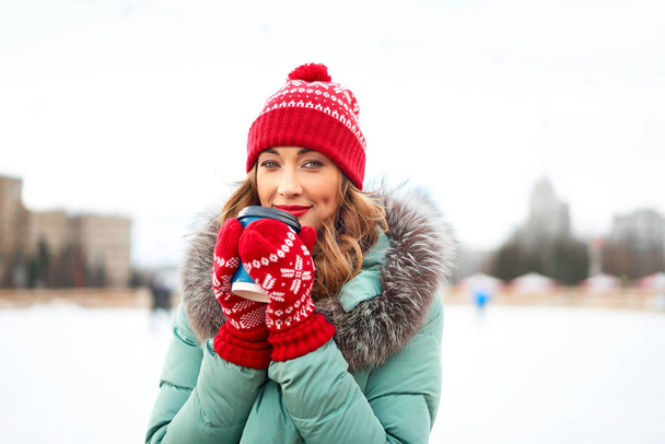 Beautiful lovely middle-aged girl with curly hair warm winter jackets stands ice rink background Town Square. - Photo, image