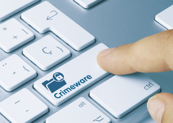 Crimeware Written on Blue Key of Metallic Keyboard. Finger pressing key. - Photo, Image