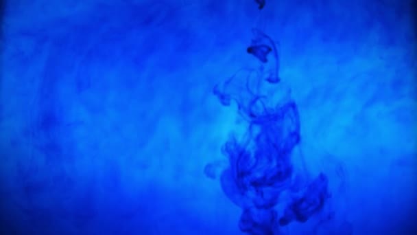 Μπλε χρώμα μελάνι χρώμα ρίχνει πάνω από το γυαλί με μελανί σταγόνες που πέφτουν και αφηρημένη έκρηξη καπνού υδατογραφίες - Πλάνα, βίντεο