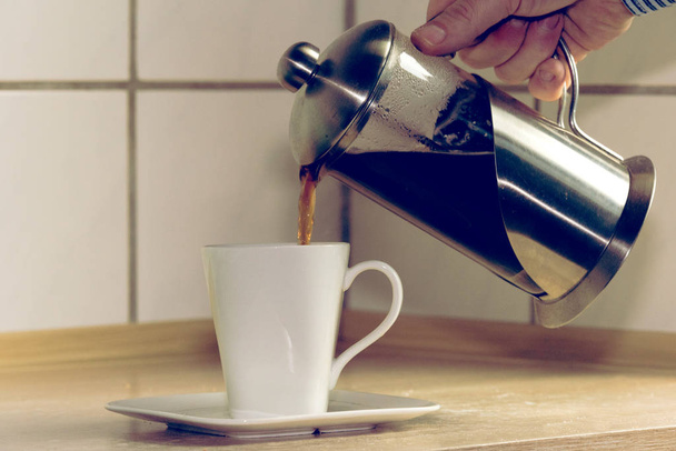 recortado tiro de persona vertiendo café en taza - Foto, Imagen