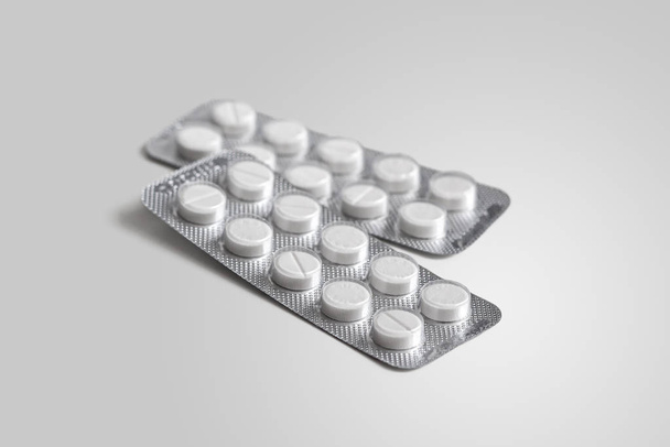 Két buborékcsomagolás fehér tablettával fehér alapon - Fotó, kép