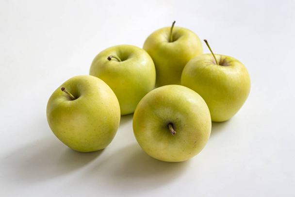 Cinq pommes jaune-vert sur un fond clair
 - Photo, image