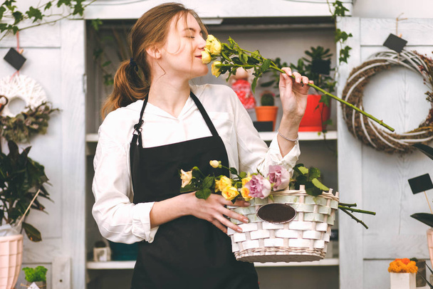 Florist of flower shop sniffing rose - Photo, Image
