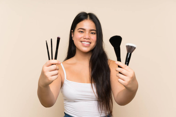 Joven adolescente asiático chica holding maquillaje cepillo
 - Foto, Imagen