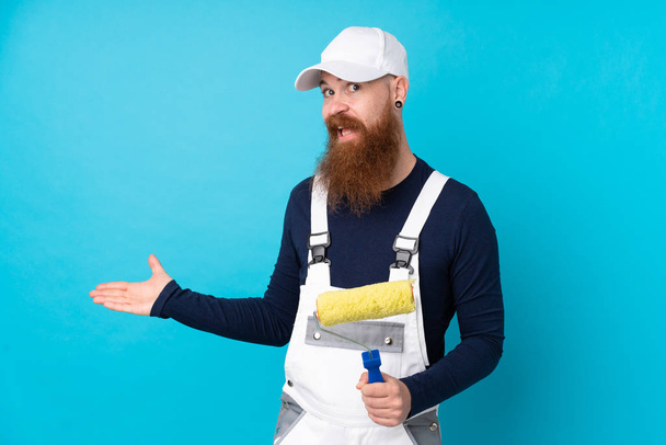 Живописець з довгою бородою над ізольованим синім тлом, що розтягує руки на бік, щоб запросити прийти
 - Фото, зображення
