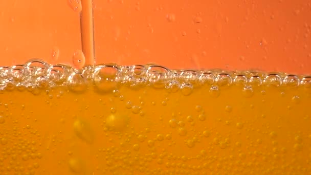 Nahaufnahme Hintergrund des Einfüllens von Sodawasser mit Blasen, Sekt, Champagner oder Bier im Glas, Seitenansicht niedrig, Zeitlupe - Filmmaterial, Video