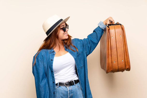 Ragazza viaggiatore rossa con valigia su sfondo isolato con espressione felice
 - Foto, immagini