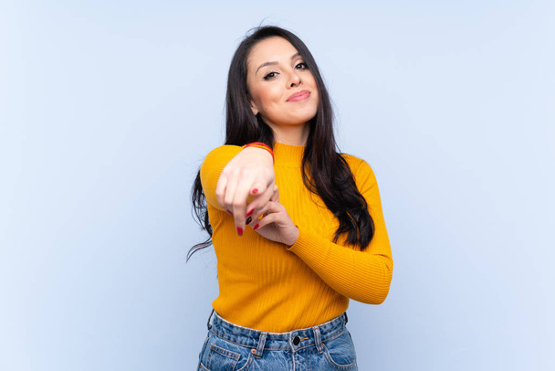 Jeune colombienne sur fond bleu isolé pointe du doigt vers vous avec une expression confiante
 - Photo, image