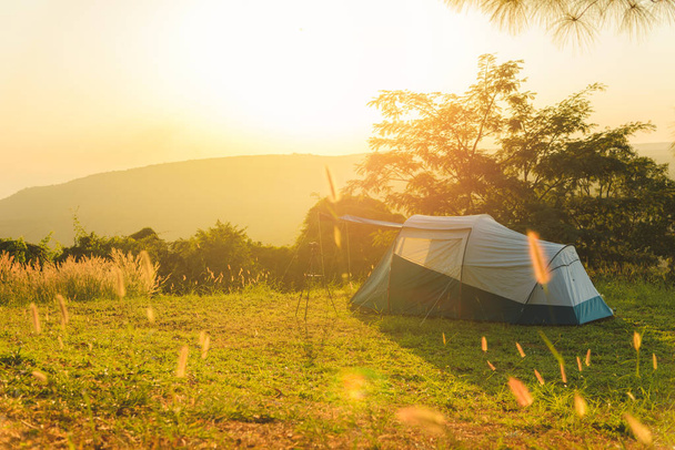 Tienda turística en el prado en la puesta de sol con vistas a las montañas. camping al aire libre
 - Foto, imagen