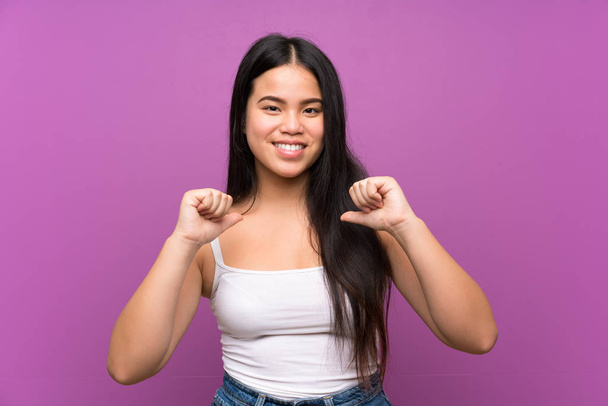 Young teenager Asian girl over isolated purple background proud and self-satisfied - Foto, Imagem