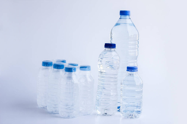 close-up shot of plastic bottles of water on white surface - Foto, Imagen