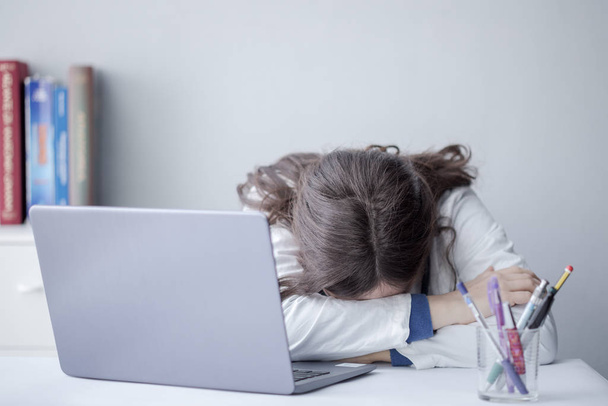 Cansado jovem mulher médico trabalhando com um laptop em uma clínica
 - Foto, Imagem