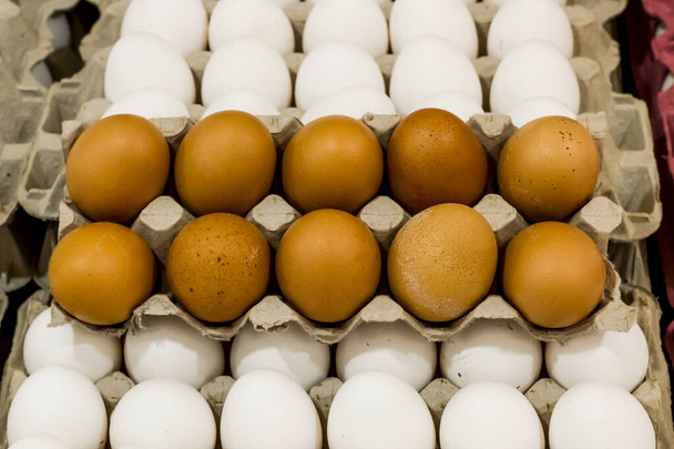 close-up shot of raw brown and white chicken eggs in cartons - Foto, afbeelding