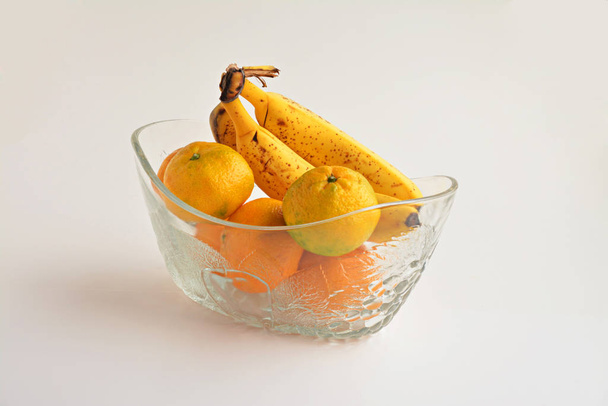 close-up shot of delicious tangerines and banana on white - Foto, Bild