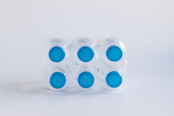 close-up shot of plastic bottles of water on white surface - Foto, Bild