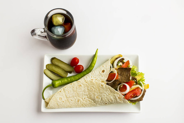 Make sandwich by doner,sour cream,tomato,onion and lettuce leaf.Put tomato on dner in pita bread on the white background. - Fotoğraf, Görsel