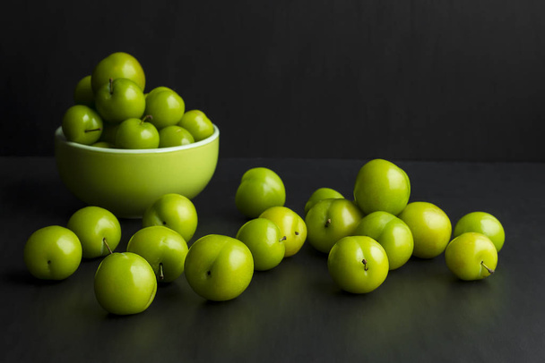 close-up shot of delicious green cherry plums on black - 写真・画像