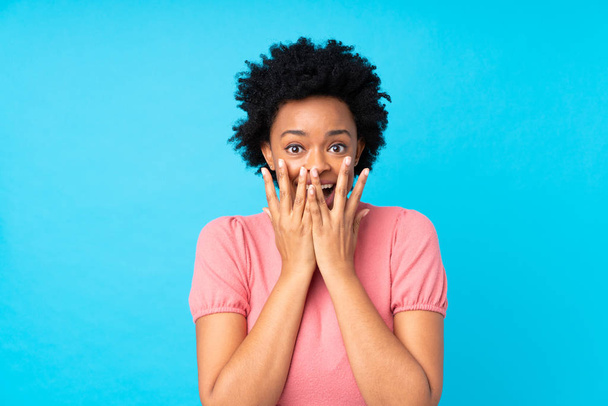 African american woman over isolated blue background with surprise facial expression - Photo, image