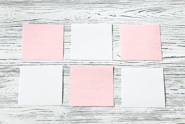 weiße und rosa Papierblätter auf einem Holztisch. Abstrakter Hintergrund - Foto, Bild