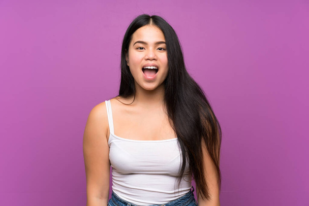 Young teenager Asian girl over isolated purple background with surprise facial expression - Fotoğraf, Görsel