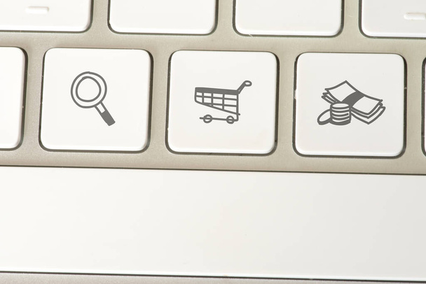 Ένας υπολογιστής και κλειδιά για αναζήτηση, ψώνια και πληρωμή - Φωτογραφία, εικόνα