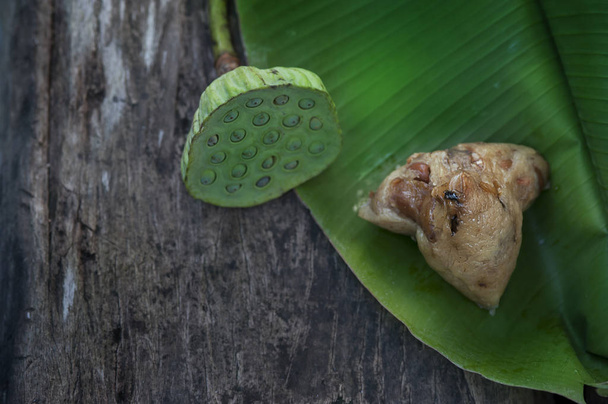 Zongzi lub tradycyjne chińskie pierogi ryżowe Sticky rozpakowane na liściu banana ozdobione nasionami lotosu - Zdjęcie, obraz