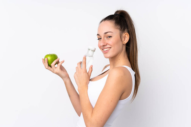fiatal barna nő izolált fehér háttér egy alma és egy üveg víz - Fotó, kép