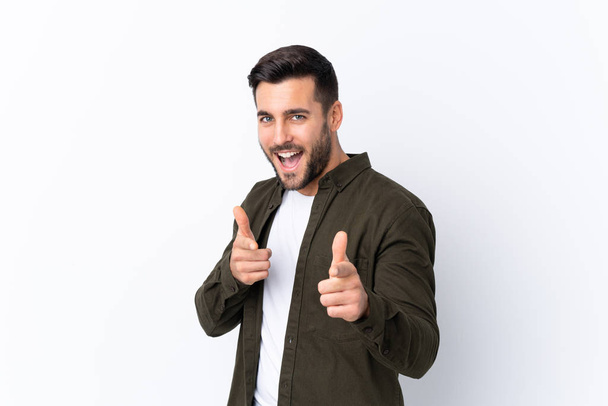 Young handsome man with beard over isolated white background pointing to the front and smiling - Photo, image