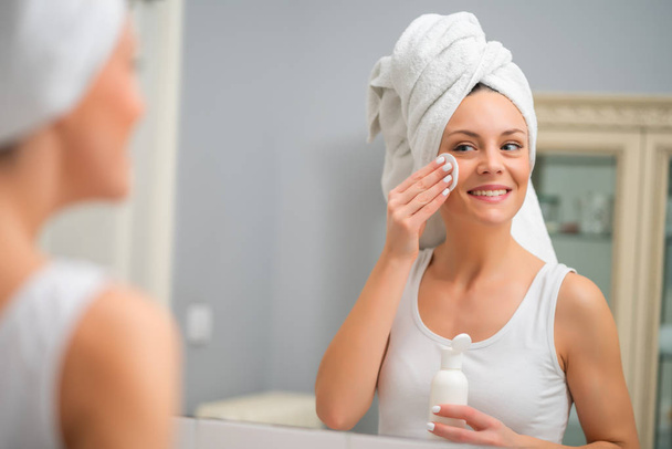Portrét mladé ženy, která je čištění kůže na tváři. - Fotografie, Obrázek