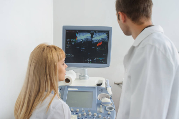 Twee artsen kijken naar de Ultrasonografie apparaat - Foto, afbeelding