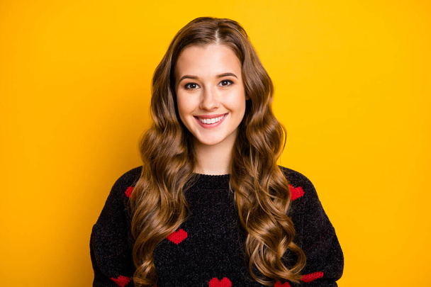 Close-up portrait of her she nice attractive lovely winsome cheerful cheery wavy-haired girl wearing black pullover heart festal print isolated on bright vivid shine vibrant yellow color background - Foto, Imagen
