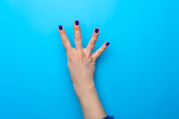 Female hand with dark blue nails showing gesture - Photo, Image