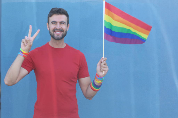 Yakışıklı erkek gururla Lgbt bayrağını tutuyor. - Fotoğraf, Görsel