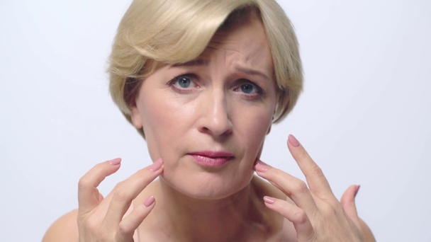 elégedetlen érett nő megható arc elszigetelt fehér  - Felvétel, videó