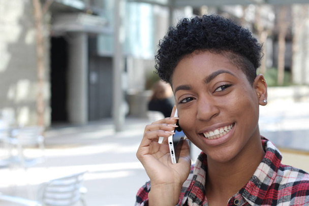 Afrikaanse vrouwelijke student met behulp van telefoon op de campus  - Foto, afbeelding