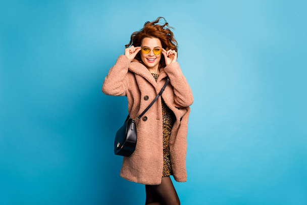 Portrait of cute pretty content woman touch yellow sunglass enjoy season holiday wear look good clothes cotton pantyhose stockings isolated over blue color background - Foto, immagini
