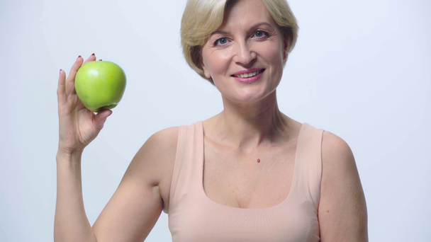 ώριμη γυναίκα που κρατά το μήλο απομονωμένο σε λευκό  - Πλάνα, βίντεο