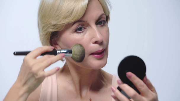 ελκυστική ώριμη γυναίκα εφαρμογή μακιγιάζ απομονώνονται σε λευκό  - Πλάνα, βίντεο