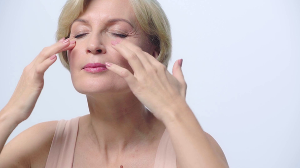 mujer madura haciendo masaje facial aislado en blanco
  - Metraje, vídeo