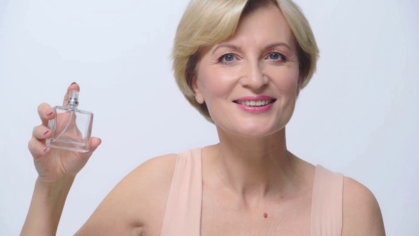 volwassen vrouw ruiken parfum geïsoleerd op wit  - Video