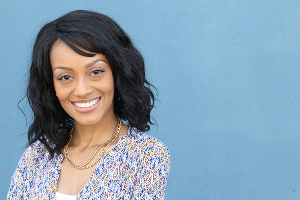 Close-up beauty portret van een jonge en aantrekkelijke Afro-Amerikaanse zwarte vrouw met perfecte huid, zacht glimlachend. Gezondheid en schoonheid buiten levensstijl - Foto, afbeelding