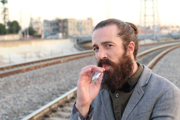 Стильная бородатая модель хипстера с мужской прической булочки, стиль жизни на улице, глубина резкости
 - Фото, изображение
