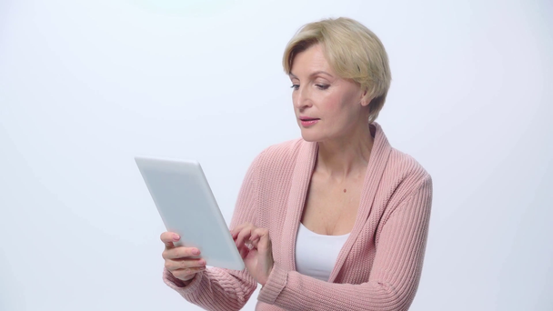 volwassen vrouw met behulp van digitale tablet geïsoleerd op wit  - Video