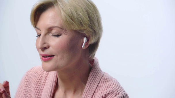 ώριμη γυναίκα ακούει μουσική απομονωμένη σε λευκό  - Πλάνα, βίντεο